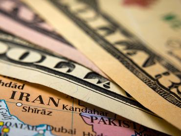 Dollar bills on top of a map of Iran