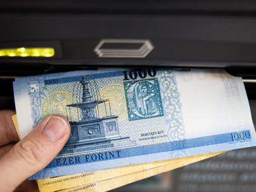 Close-up of a person withdrawing Hungarian Forint banknotes from an ATM machine. Photographer: Akos Stiller/Bloomberg