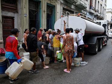 People gather around a water tanker truck to fill up buckets and other containers as severe fuel shortages have disrupted water pumping and distribution, in Havana, Cuba March 19, 2026. REUTERS/Norlys Perez TPX IMAGES OF THE DAY