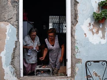 Mirna Clavijo, 84, and her daughter Isabel Gutierrez, 61, cook dinner as Cuba's national electric grid collapsed for the second time in a week amid the U.S.-imposed oil blockade, according to officials, as the communist government struggles to keep the lights on for about 10 million people with decrepit infrastructure, in Havana, Cuba, March 21, 2026. REUTERS/Norlys Perez