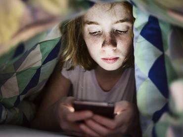 Mädchen, teenager,mit smatphone nachts unter der Bettdecke, Köln, Nordrhein-Westfalen, Deutschland